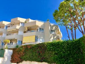 a large white building with trees and bushes at Luxury Doña Carlota in Torremolinos