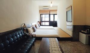 una camera d'albergo con due letti e un divano di GOIN Old House & Bar a Tainan