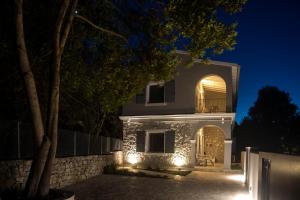 a house lit up at night with lights at Avali luxury houses in Gaios