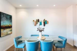 リスボンにあるFLH Restauradores Modern Apartmentのダイニングルーム(テーブル、青い椅子付)