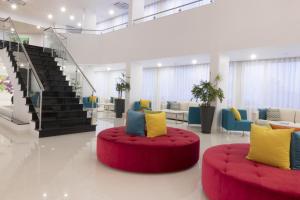 a large lobby with a red couch and chairs at Luna Miramar Club in Albufeira