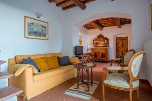 ein Wohnzimmer mit einem Sofa und einem Tisch in der Unterkunft Fattoria Poggio di Fiesole in Fiesole