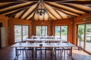 a large room with tables and chairs and windows at Paraiso Rural in Villanueva de Cameros