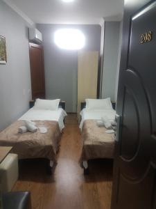 a small room with two beds in a room at Hotel LEADER in Tbilisi City