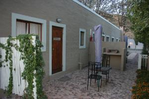 a patio of a house with chairs and a table at And the cow jumped over the moon... in Nieu-Bethesda