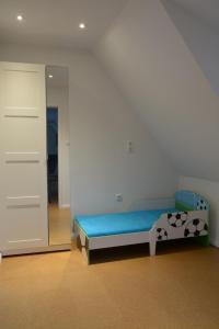 1 dormitorio con cama azul y espejo en Ferienhaus BAUMBLÜTE, en Werder