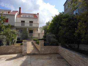 a house with a brick wall in front of a building at Apartments D & P in Korčula