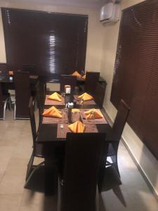 a dining room with a table and chairs with tables and chairsktop at Posh Apartments Business Hotel in Ikeja