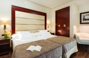 a hotel room with a bed with two books on it at Hotel Valencia Center in Valencia