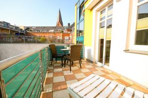 a balcony with a table and chairs on a building at Ferienwohnung Min Herzing in Warnemünde