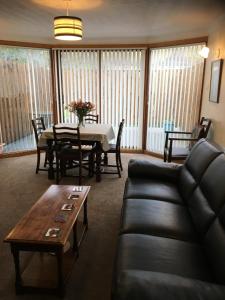 a living room with a couch and a table at Treetops Bungalow Loch Ness in Drumnadrochit