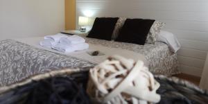 Una habitación de hotel con una cama con toallas. en Pensión La Estación, en Sarria