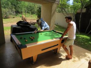 two men playing pool with a pool table at Iwa Imfene Pvt Game Lodge, Welgevonden IMW2 in Welgevonden Game Reserve