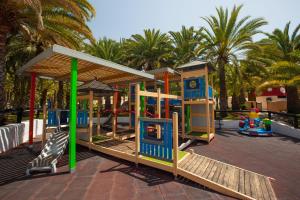 un patio de recreo en un parque con palmeras en Grupotel Orquidea, en San Agustín
