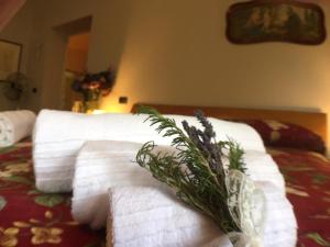 - une pile de serviettes sur un lit avec une plante dans l'établissement Villa Pieve De' Pitti, à Terricciola