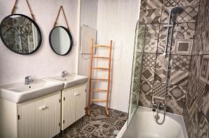 a bathroom with a sink and a shower and a mirror at Old Charming House Faro in Faro