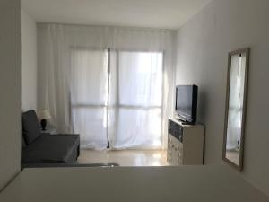a living room with a tv and a window at Apartament Trinisol ll with sea view in Benidorm