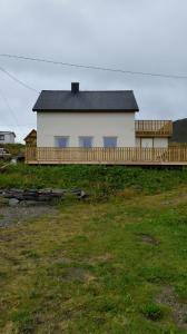Biały dom z czarnym dachem na polu w obiekcie Elfridastua w mieście Sørvær
