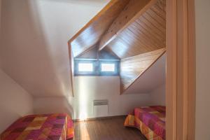 a attic bedroom with two beds and a staircase at VVF Résidence Les Angles Pyrénées in Les Angles