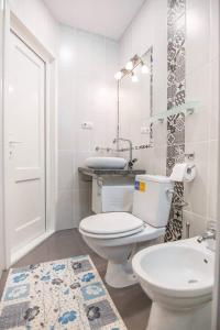 biała łazienka z toaletą i umywalką w obiekcie Pensiunea San Gennaro w mieście Miercurea-Ciuc