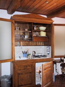 eine Küche mit einem Holzschrank und einem Kühlschrank in der Unterkunft Lauro in Castellina in Chianti