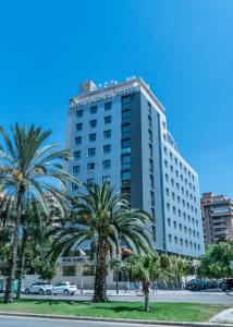 un edificio alto con palmeras delante en Hotel Valencia Center, en Valencia