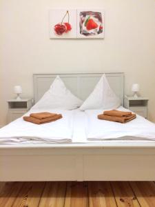 a white bed with two towels on top of it at Rooms & Apartments near Zoologischer Garten in Berlin