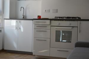 a kitchen with white cabinets and a sink and a stove at Casa Vacanze Matilda in Varazze