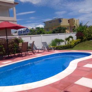 Bazén v ubytování Fayruz Villa is a 3 bedroom, 3 bathroom detached house with AC and swimming pool 5 minutes walk from Flic en Flac public beach nebo v jeho okolí