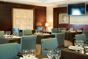 Un restaurante con mesas, sillas y copas de vino. en Hotel Valencia Center, en Valencia