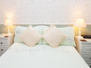 1 dormitorio con cama blanca y almohadas en Crimdon Dene en Torquay