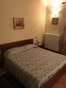 een slaapkamer met een bed, een lamp en een radiator bij B&B Cantine Pietronero in Orsara Bormida