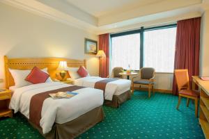 a hotel room with two beds and a table and chairs at BEST WESTERN PLUS Hotel Hong Kong in Hong Kong