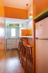 La Rotonda da Sabrina B&B في باري: مطبخ بجدران برتقالية وطاولة وكراسي