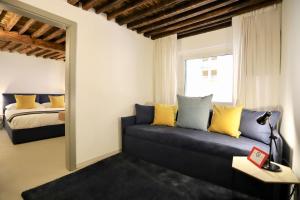 - un salon avec un canapé et un lit dans l'établissement San Lorenzo Small Apartment, à Gênes