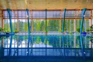 a swimming pool with a large window in a building at Hotel Perła Południa in Rytro