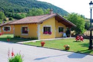 a small yellow house with a playground in the yard at CASUCAS LA GUARIZA - Casa Susi - in Fontibre