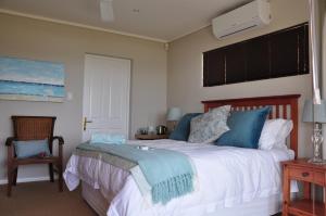 a bedroom with a large bed with blue pillows at Zeezicht Guest House in De Kelders +101 photos