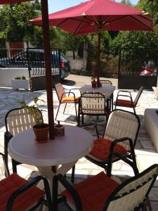 a table with chairs and umbrellas on a patio at Remezzo Apartments in Sami