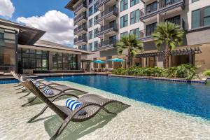 ダバオシティにあるdusitD2 Davaoのラウンジチェア付きのスイミングプールが隣接しています。