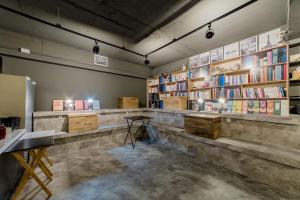 una stanza con scaffali di libri e un tavolo di Guesthouse Dear Moon a Busan