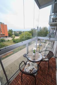 balkon ze stołem i krzesłami w obiekcie VIP apartaments - Zalgirio 96 w Wilnie