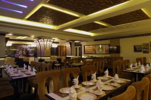 Un restaurante con mesas y sillas con servilletas. en Nagpal Regency, en Ludhiana