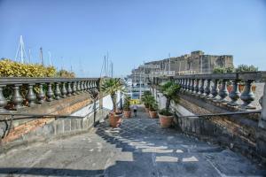 eine Reihe Topfpflanzen an einer Wand mit einem Hafen in der Unterkunft il faro di serapide in Neapel