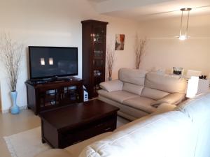 a living room with a couch and a flat screen tv at Chalet adosado 3 dormitorios in Sant Jordi