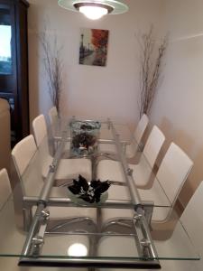 une table en verre avec des chaises blanches et un vase sur celle-ci dans l'établissement Chalet adosado 3 dormitorios, à Sant Jordi