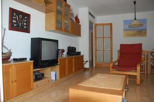 sala de estar con TV y silla en Apartamento con ubicación inmejorable en Platja  d'Aro