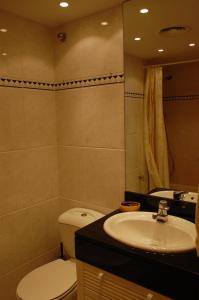 y baño con aseo y lavamanos. en Apartamento con ubicación inmejorable en Platja  d'Aro