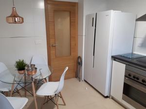 a kitchen with a white refrigerator and a table and chairs at Chalet adosado 3 dormitorios in Sant Jordi