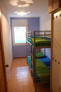 una habitación con tres literas y una ventana en Apartamento con ubicación inmejorable, en Platja d'Aro